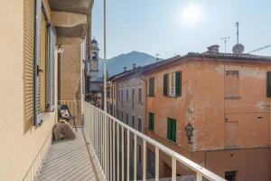 una donna seduta sul balcone di un edificio di Apt in centro storico a due passi dal lago a Cernobbio