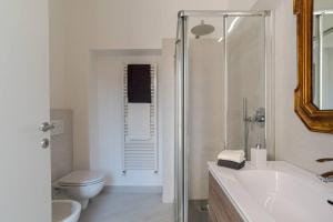 een badkamer met een wastafel, een toilet en een douche bij Apt in centro storico a due passi dal lago in Cernobbio