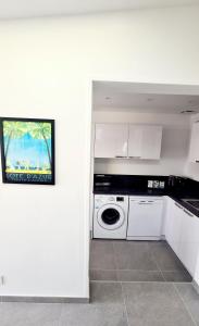 a white kitchen with a washing machine in it at MAGNIFIQUE APPARTEMENT T4 GRAND STANDING - VUE MER PANORAMIQUE ET PISCINE in Bandol