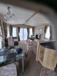 a living room with a couch and a table at Caravan L16 in Mablethorpe