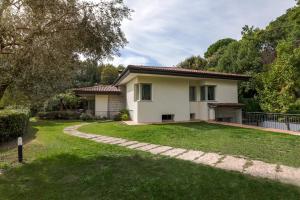 ein Haus mit Rasen davor in der Unterkunft Villa Tullia in Padenghe sul Garda