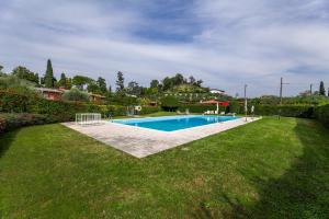 ein Schwimmbad in der Mitte eines Gartens in der Unterkunft Villa Tullia in Padenghe sul Garda