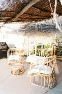 un groupe de chaises et de tables en osier dans une pièce dans l'établissement Tortuga blue house in banana plantation, à Arucas