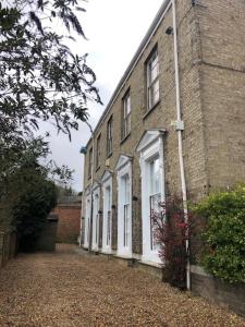 a brick building with white doors and windows at Unique Georgian Splendour at The Old Ballroom sleeps 2 with sofabed 4 add The Studio at extra cost to sleep 2 more in Norwich