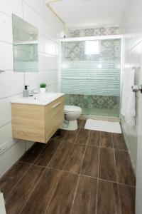 y baño con aseo, lavabo y espejo. en Westpunt Beach Apartments, en Willemstad