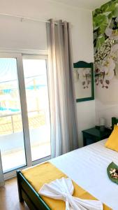 a bedroom with a bed and a large window at D&R Sunshine Apartment in Nea Kydonia