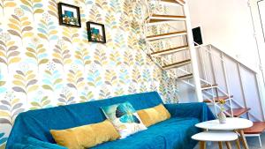 a blue couch in a living room with a wall at D&R Sunshine Apartment in Nea Kydonia