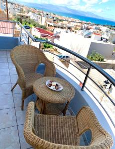 a balcony with two chairs and a table with a bowl of food at D&R Sunshine Apartment in Nea Kydonia