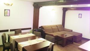 una sala da pranzo con tavoli e divano di Traveland Boutique Resort Poiana Brasov a Poiana Brasov