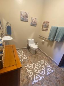 a bathroom with a toilet and a sink at Dolphin Beach Get Away in Rosarito