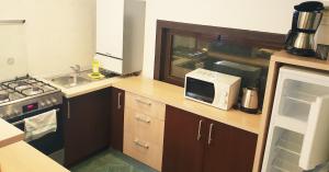 a small kitchen with a microwave and a sink at Traveland Boutique Resort Poiana Brasov in Poiana Brasov