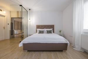a bedroom with a large bed and a glass wall at City Central in Ljubljana
