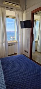 een slaapkamer met een blauw bed en uitzicht op de oceaan bij IRIDE SUL LAGO 1 Via Principessa Jolanda 10-Piazza del Molo in Anguillara Sabazia