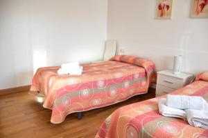 a room with two beds and a table at CASA RAICHU in Obanos