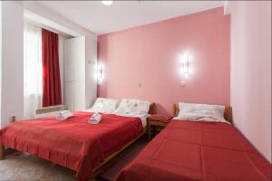 two beds in a room with pink walls at Vila Kosta City Center Port in Ohrid