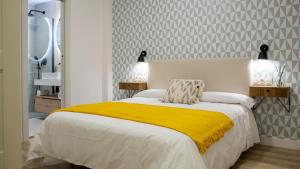 1 dormitorio con 1 cama con manta amarilla en Precioso apartamento en Jaén a 70 m de la Catedral en Jaén