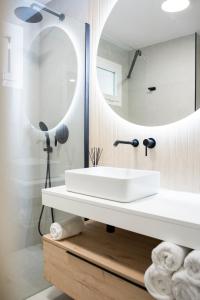 y baño con lavabo blanco y espejo. en Precioso apartamento en Jaén a 70 m de la Catedral en Jaén