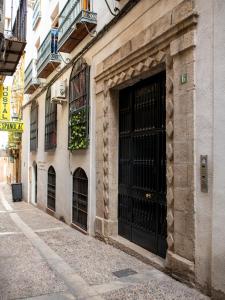 un edificio con dos grandes puertas negras en una calle en Precioso apartamento en Jaén a 70 m de la Catedral en Jaén