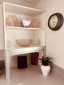 a shelf with bowls and a clock on a wall at Cottage on Harrogate in Hanmer Springs