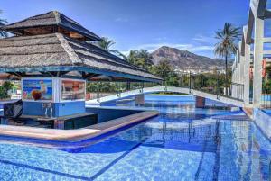 una piscina en un complejo con cenador en EL ESTUDIO DE LA PLAYA BENALBEACH NEW 1BD, Piscinas, playa y vistas al mar Ref504, en Benalmádena