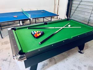 a pool table with balls and cuesticks on it at Cottage on Harrogate in Hanmer Springs