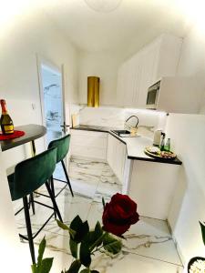 una cocina con armarios blancos y una rosa roja en el suelo en Apartament z jacuzzi - Centrum Szczytna Mazury, en Szczytno