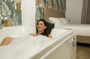 a woman is sitting in a bath tub at Galileo Suite in Trani