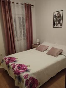ein Schlafzimmer mit einem Bett mit Blumen darauf in der Unterkunft Apartmani Bilić in Dugi Rat