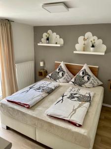 Schlafzimmer mit einem Bett mit zwei Eulenkissen in der Unterkunft Haus SauerlandLiebe in Schmallenberg