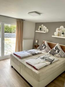 Un dormitorio con una cama grande y una ventana. en Haus SauerlandLiebe, en Schmallenberg