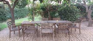 einen Holztisch und Stühle auf einem gemauerten Boden in der Unterkunft Barnet House Lamezia in Lamezia Terme