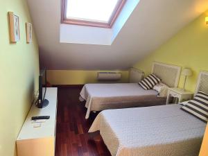 a small room with two beds and a window at El ático de la Gorga in Boltaña +63 photos
