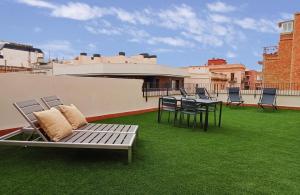 eine Terrasse mit Stühlen und einem Tisch auf dem Dach in der Unterkunft Feelathome Stadium Apartments in Hospitalet de Llobregat