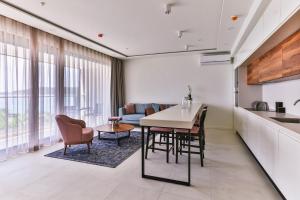 a kitchen and living room with a table and chairs at Montesun RAF Apartments in Budva
