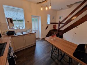 cocina con fregadero y mesa de madera en Albert Cottage en Skipton