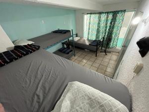 um quarto com uma cama e um quarto com uma janela em Nómadas Hostel em La Paz