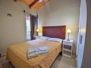 1 dormitorio con 1 cama con toallas en La Caballeriza Alojamiento Alta Gracia en Alta Gracia