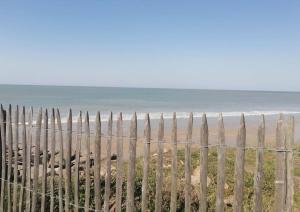 une clôture sur une plage avec l'océan en arrière-plan dans l'établissement Le Courlis, à deux minutes de la plage, à Hauteville-sur-Mer
