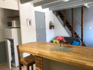 cocina y comedor con mesa de madera en AU MIMOSA - Gîte Le Murier, en Passa