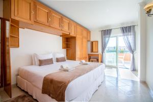 een slaapkamer met een groot bed en een groot raam bij Apartamento King in Vilamoura
