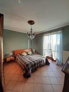 a bedroom with a bed and a chandelier at Casa Vacanze Le tre Sorelle in Torre Pellice