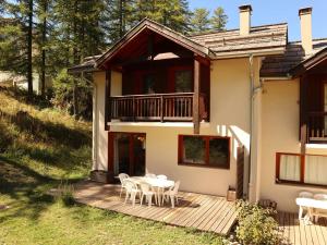 a house with a deck with a table and chairs at Chalet Les Orres, 5 pièces, 10 personnes - FR-1-322-65 in Les Orres