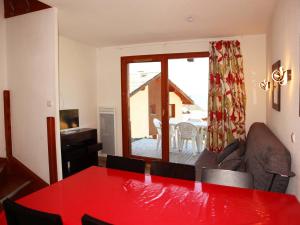 uma sala de estar com uma mesa de jantar vermelha em Chalet Les Orres, 3 pièces, 6 personnes - FR-1-322-124 em Les Orres