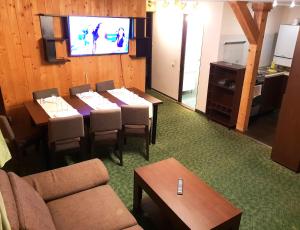 a dining room with tables and a flat screen tv at Traveland Boutique Resort Poiana Brasov in Poiana Brasov +52 photos