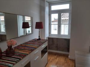 a room with a counter with a mirror and two windows at Casa da Travessa II in Ponte de Lima