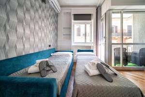 deux lits assis dans une pièce avec une fenêtre dans l'établissement Dante 138 Class rooms & apartments, à Bari