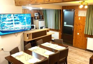 a restaurant with tables and a large tv on the wall at Traveland Boutique Resort Poiana Brasov in Poiana Brasov