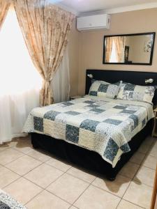 a bedroom with a bed with a blue and white quilt at JoThams Bed & Breakfast or Self-catering in Durban