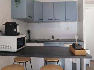 una cucina con bancone, forno a microonde e sgabelli di Studio Les Orres, 1 pièce, 4 personnes - FR-1-322-479 a Les Orres