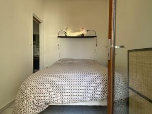 sypialnia z łóżkiem i półką na ścianie w obiekcie Appartement 2 pièces avec balcon, piscine, proche plage à Dolus-d'Oléron - 4 couchages - FR-1-246A-182 w mieście Dolus d'Oléron +8 zdjęć